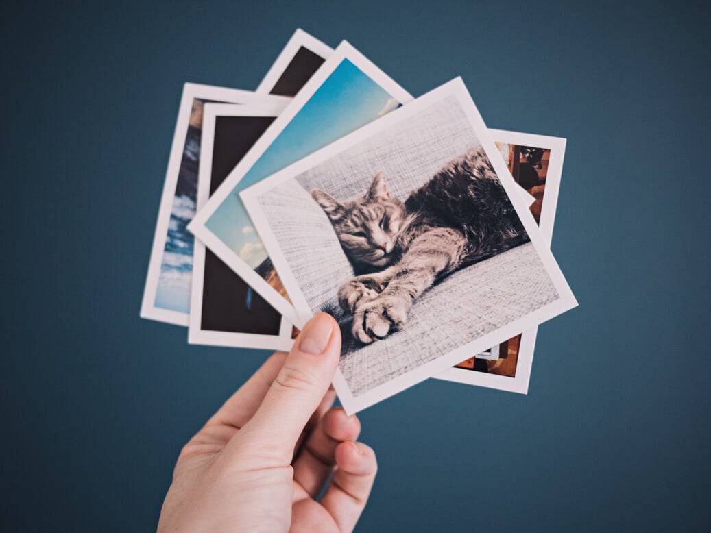 Woman holding social media photo prints