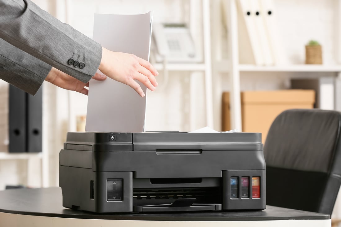 Businesswoman with Paper near Printer in Light Office